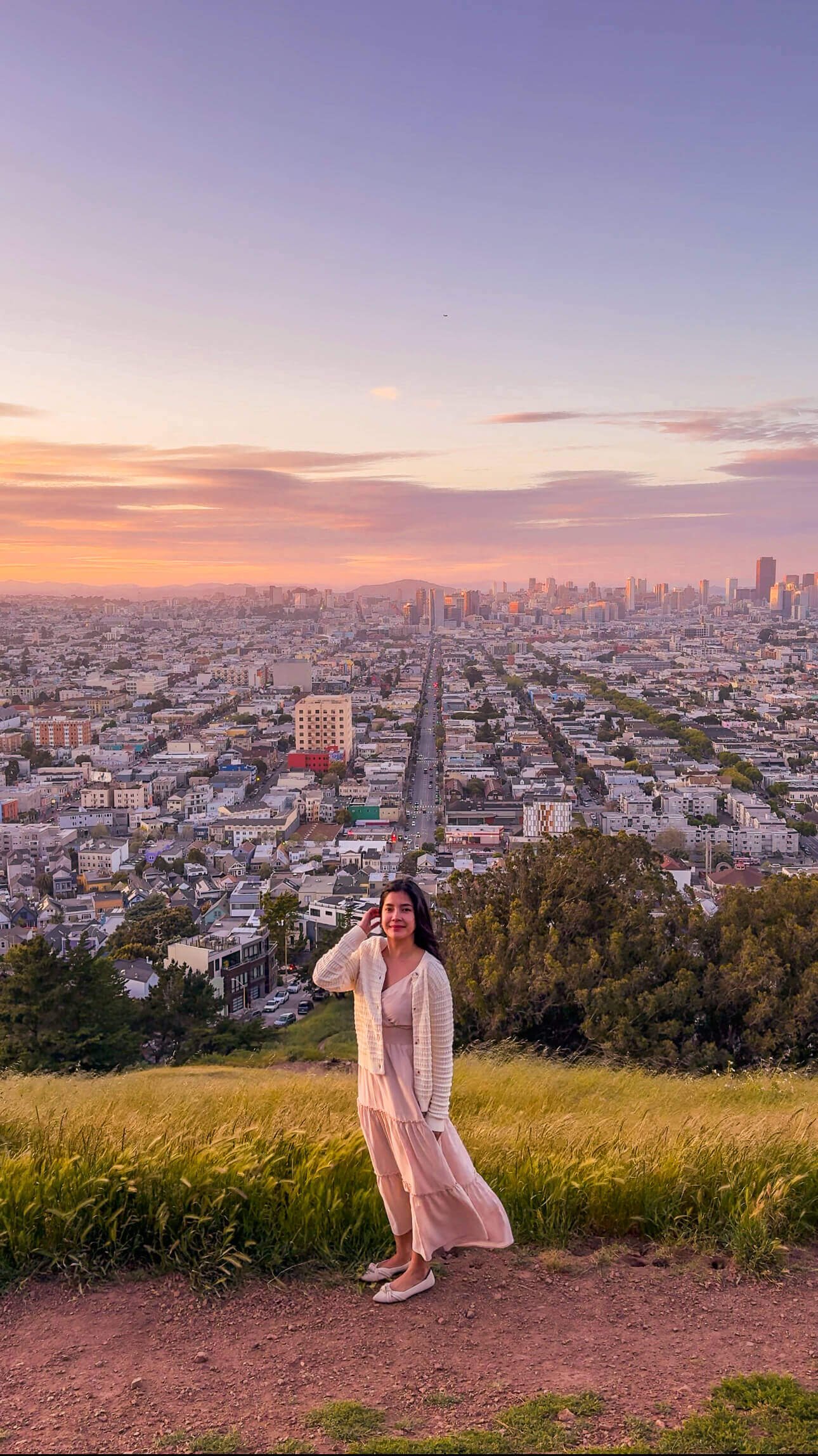 Lisa enjoying a stunning sunset at Bernal Heights Park in San Francisco, with panoramic city views in the background