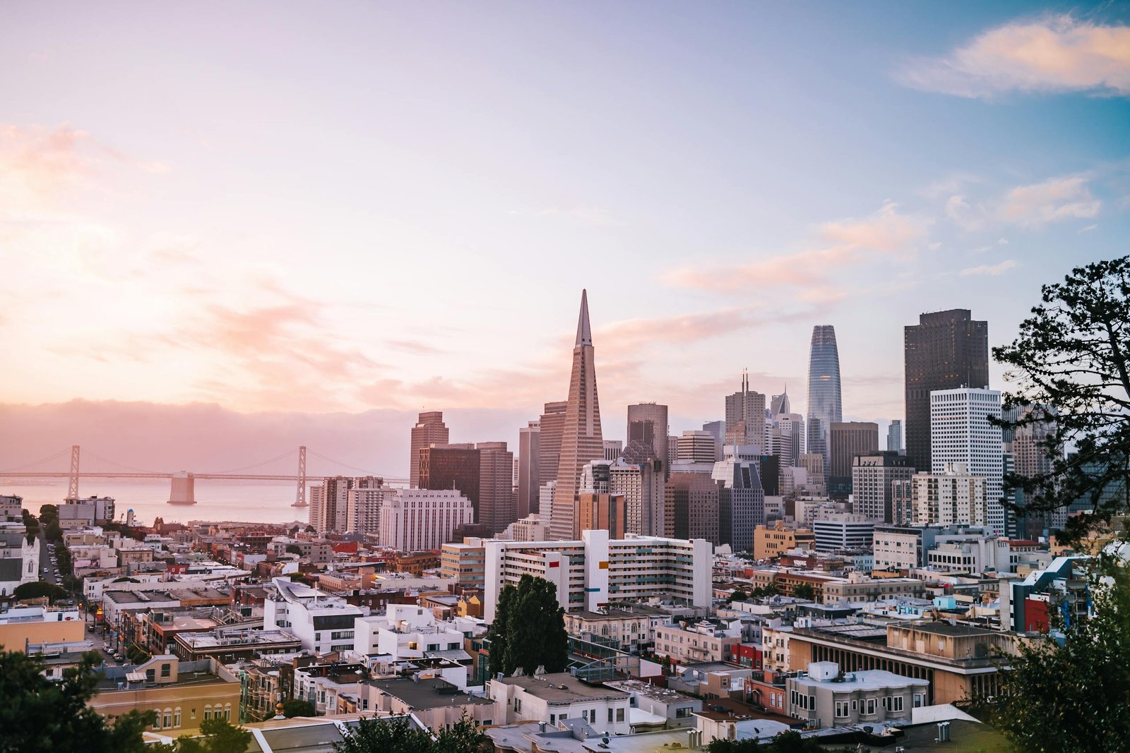 Stunning view of San Francisco cityscape with iconic landmarks during sunrise.