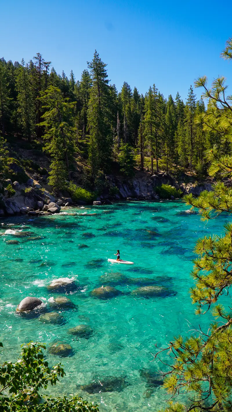 Crystal clear turquoise water at Lake Tahoe California surrounded by pine trees