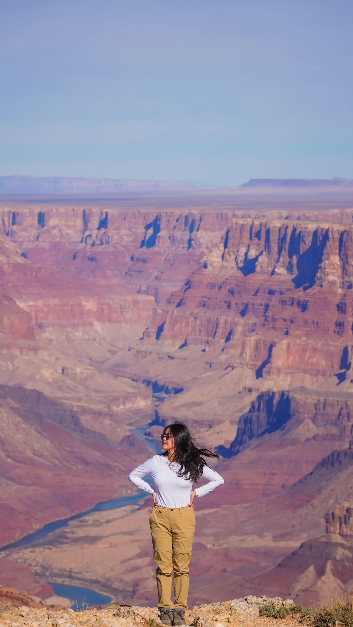 Woman standing on edge of canyon overlooking vast Southwest USA landscape