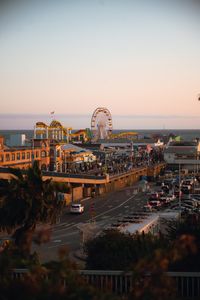 Beautiful aerial view of Santa Monica Pier at sunset, with bustling streets and iconic Ferris wheel.