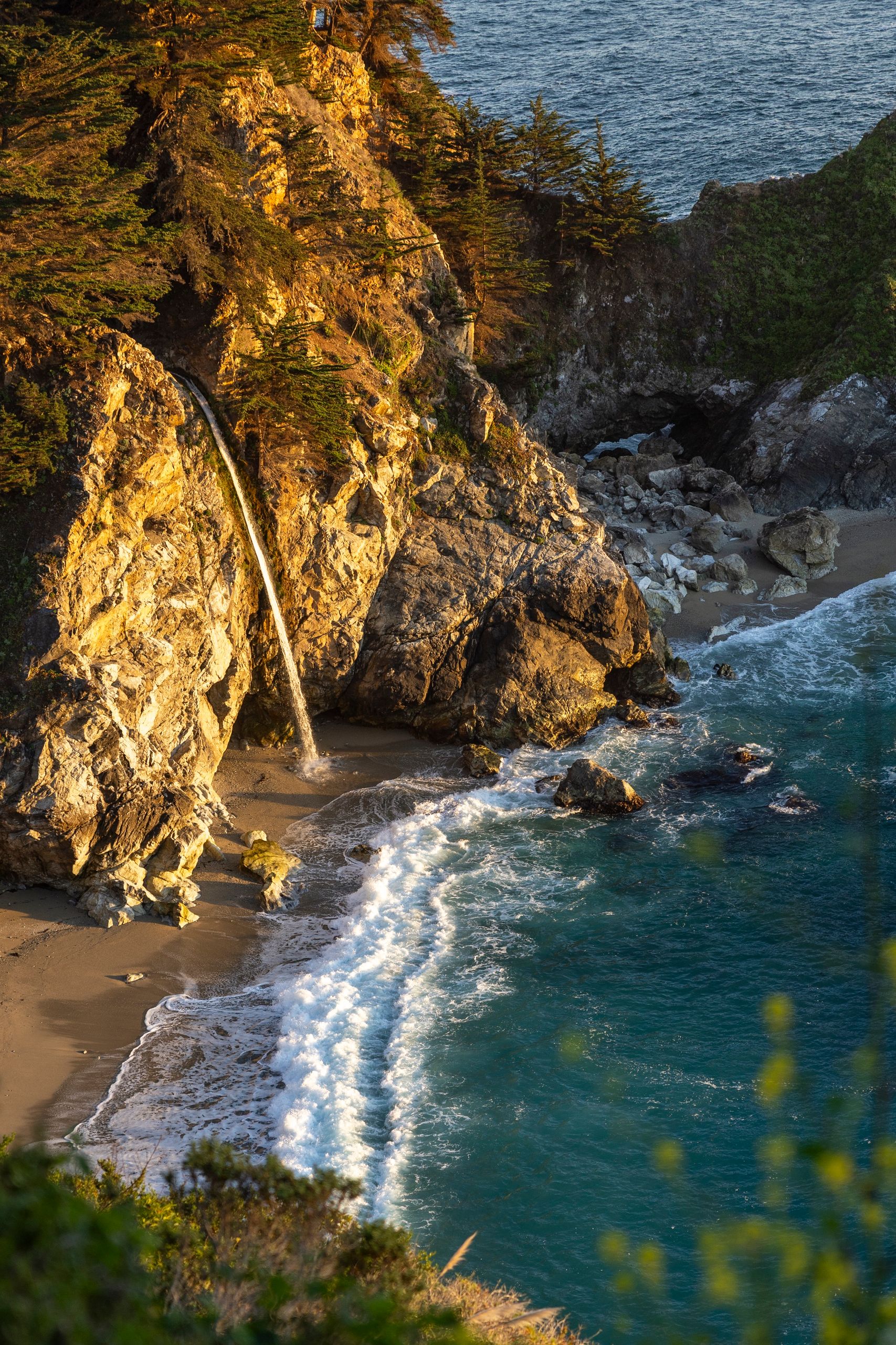 Experience the serene beauty of McWay Falls cascading into the ocean at sunset in Big Sur, California.